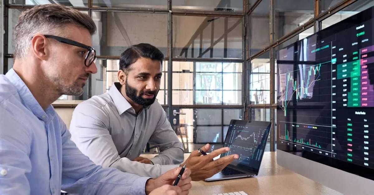 Image shows NetSuite consultant meeting with client. Both are looking at a monitor.